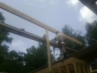 Carpenter setting a ridge beam over a new addition frame — Ice Dam Removal by Roofing Brothers in Wabasha