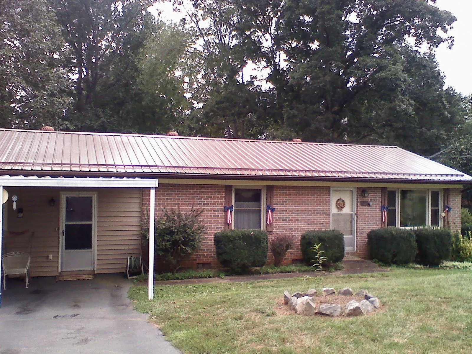 Bronze metal roof and carport on a brick ranch home — Roof Repair work by our crew in Wabasha